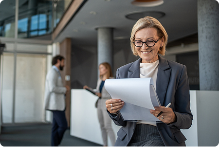 A woman reading files with a smile